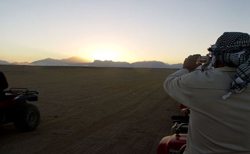 фотографирование фотографирующего закат в пустыне.